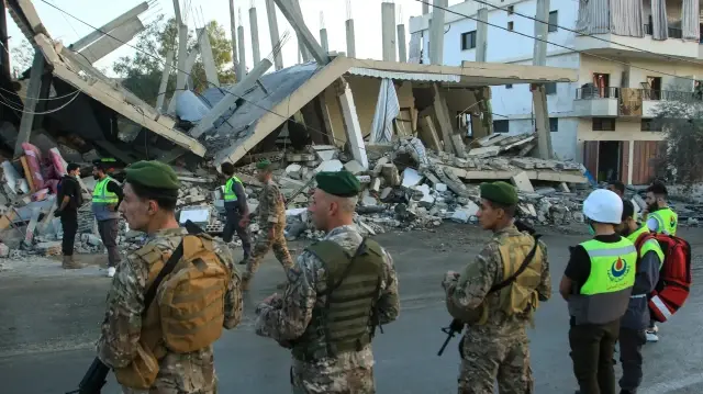Des soldats de l'armée libanaise sécurisent le site d'une frappe aérienne israélienne qui a visé un bâtiment dans le village de Deir Kifa, dans le sud du Liban, le 19 novembre 2025.