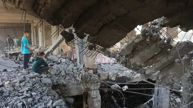 Des enfants palestiniens inspectent les décombres d'un bâtiment endommagé appartenant au ministère des Affaires religieuses, qui abritait des personnes déplacées dans le quartier de Zeitoun, à Gaza, le 20 novembre 2025.