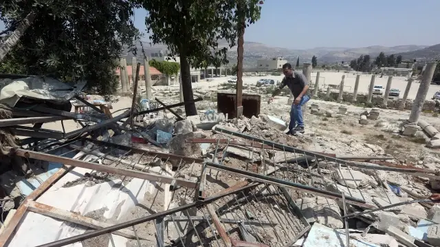 Un Palestinien marche au milieu des décombres après la démolition d'un bâtiment par les autorités israéliennes dans le village de Sebastia, près de Naplouse, en Cisjordanie occupée par Israël, le 9 août 2016.