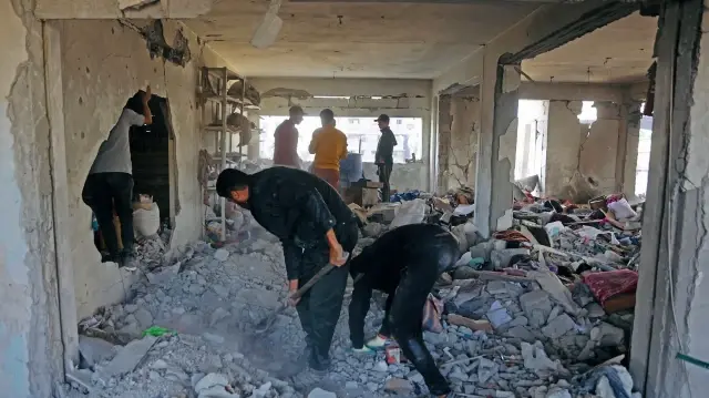 Des Palestiniens déblayent les décombres d'un bâtiment endommagé appartenant au ministère des Affaires religieuses, qui abritait des personnes déplacées dans le quartier de Zeitoun à Gaza, le 20 novembre 2025, au lendemain d'une attaque de l'armée israélienne.