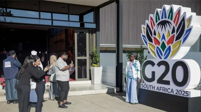 Un journaliste fait une présentation avant l'ouverture du sommet des dirigeants du G20 au Nasrec Expo Centre de Johannesburg, le 22 novembre 2025. 