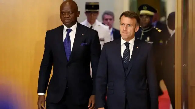 Le président gabonais Brice Oligui Nguema (à gauche) et le président français Emmanuel Macron (à droite) arrivent pour assister à une cérémonie de signature de contrat à l'issue de leur rencontre à Libreville, le 23 novembre 2025.