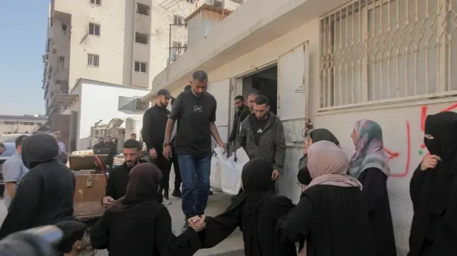 Des hommes transportent un corps recouvert d'un linceul lors des funérailles de la famille Al-Khodari à Gaza, dans la bande de Gaza, le 23 novembre 2025.