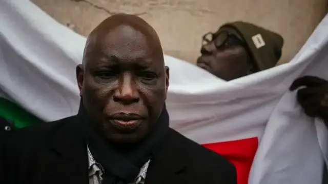 Le politicien et patron de presse sénégalais, Madiambal Diagne, poursuivi pour des accusations de blanchiment d'argent entre autres, s'entretient avec des membres de la diaspora sénégalaise après une audience à la cour d'appel de Versailles, le 25 novembre 2025, à la suite de la décision de la cour de bloquer temporairement sa demande d'extradition.