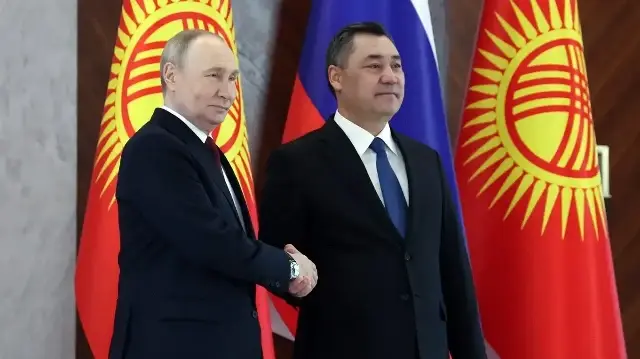 Le président russe Vladimir Poutine et le président kirghize Sadyr Japarov se serrent la main alors qu'ils posent pour les photographes lors de leurs entretiens à la résidence présidentielle Yntymak Ordo (Palais de l'Unité) à Bichkek, le 26 novembre 2025.