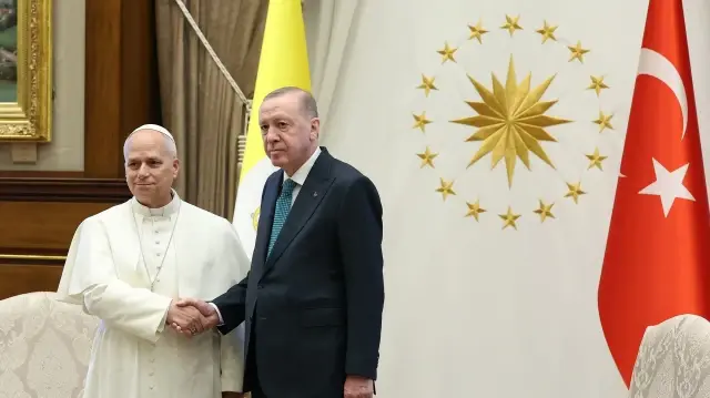 Cette photo prise et publiée par le service de presse présidentiel turc le 27 novembre 2025 montre le président turc Recep Tayyip Erdogan (à droite) serrant la main du pape Léon XIV lors d'une cérémonie officielle d'accueil au complexe présidentiel d'Ankara.
