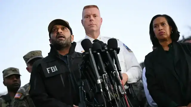 Jeffery Carroll (au centre), chef adjoint exécutif de la police métropolitaine (MPD) et Muriel Bowser (à droite), maire du district de Columbia, écoutent le directeur du FBI Kash Patel s'exprimer lors d'une conférence de presse après une fusillade dans le centre-ville de Washington, le 26 novembre 2025.