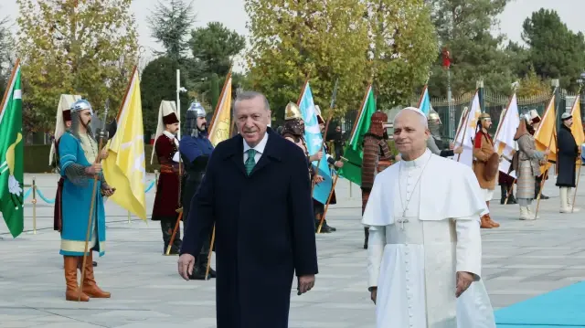 Cette photo prise et publiée par le service de presse de la présidence turque le 27 novembre 2025 montre le pape Léon XIV (à droite) et le président turc Recep Tayyip Erdogan (à gauche) passant les troupes en revue lors d'une cérémonie d'accueil à l'arrivée du pape pour une réunion au palais présidentiel d'Ankara.
