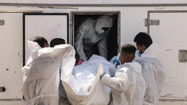 Des employés du complexe médical Nasser déchargent l'un des trente corps de prisonniers palestiniens détenus par Israël et libérés dans le cadre de l'accord d'échange d'otages, alors que les sacs mortuaires arrivent à Khan Yunis, dans le sud de la bande de Gaza, le 31 octobre 2025.