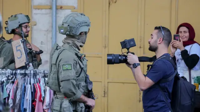 Un soldat israélien affronte des militants munis d'appareils photo à Hébron, en Cisjordanie, le 27 septembre 2025.