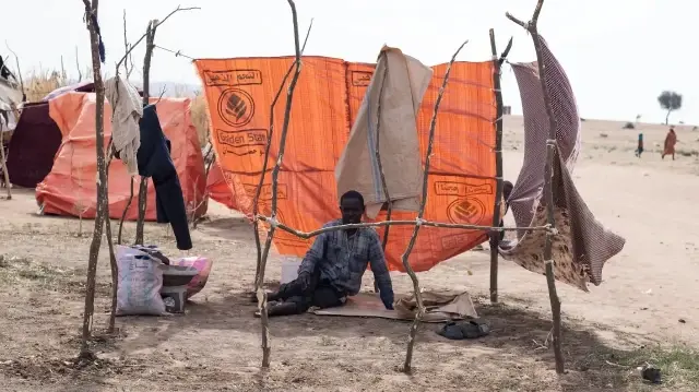 Un Soudanais déplacé qui a fui El-Fasher après la chute de la ville aux mains des Forces de soutien rapide (RSF) est assis dans un abri de fortune dans le camp d'Um Yanqur, situé à la limite sud-ouest de Tawila, dans la région du Darfour occidental, déchirée par la guerre, au Soudan, le 3 novembre 2025.