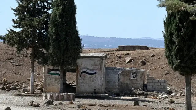 Les drapeaux de la Palestine et de la Syrie sont déployés sur une base militaire abandonnée près de la ville de Quneitra, dans le sud de la Syrie, à la lisière du plateau du Golan annexé par Israël, le 21 septembre 2025.