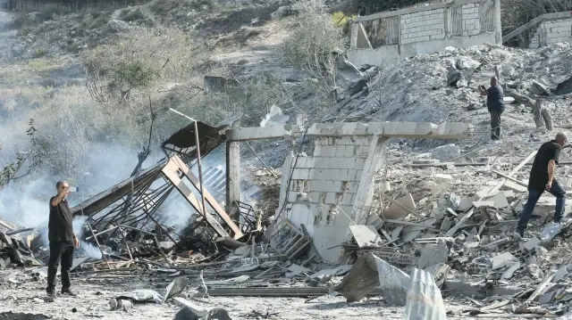 Des personnes évaluent les dégâts sur le site d'une frappe aérienne israélienne dans le village de Toura, dans le sud du Liban, le 6 novembre 2025.