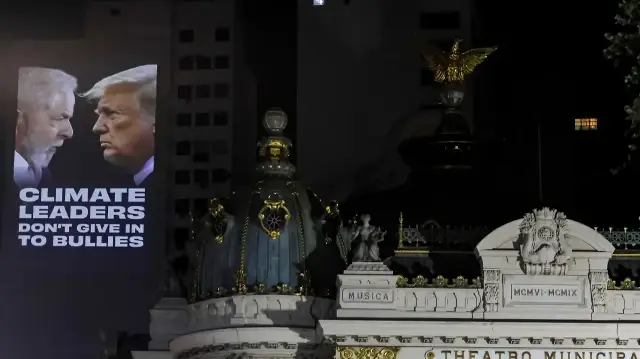 Des militants écologistes projettent des images représentant le président brésilien Luiz Inacio Lula da Silva et le président américain Donald Trump sur un bâtiment situé près du théâtre municipal, exigeant que des mesures soient prises contre le changement climatique à Rio de Janeiro, au Brésil, le 5 novembre 2025. 