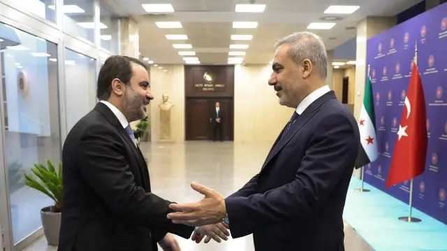 Cette photo prise et diffusée par le service de presse du ministère turc des Affaires étrangères montre le ministre turc des Affaires étrangères Hakan Fidan (à droite) serrant la main du ministre syrien des Affaires étrangères Asaad al-Shaibani à Ankara, le 8 octobre 2025.