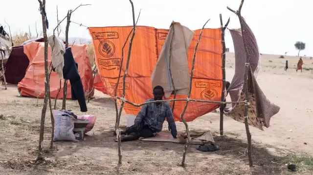 Un Soudanais déplacé qui a fui El-Fasher après la chute de la ville aux mains des Forces de soutien rapide (RSF) est assis dans un abri de fortune dans le camp d'Um Yanqur, situé à la limite sud-ouest de Tawila, dans la région du Darfour occidental, déchirée par la guerre, au Soudan, le 3 novembre 2025.