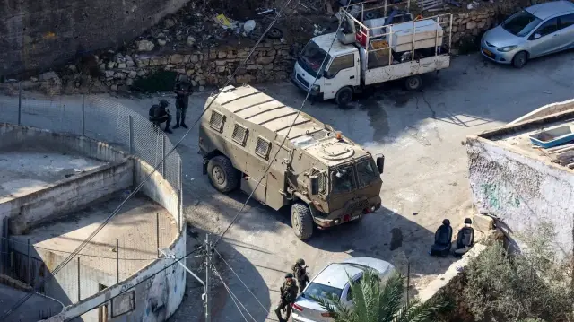 Des soldats israéliens prennent position dans le village occupé de Qatanna, en Cisjordanie occupée, avant la démolition de maisons appartenant à des Palestiniens, le 6 novembre 2025.