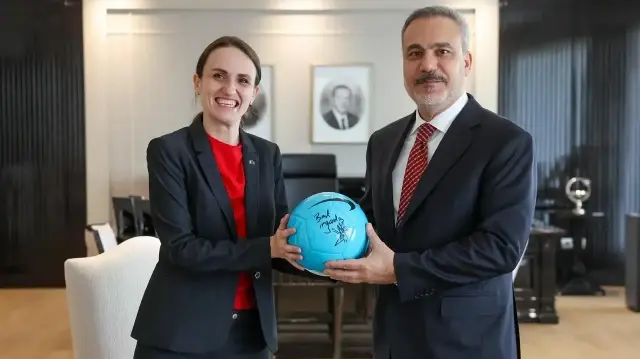 La ministre roumaine des Affaires étrangères, Oana Toiu (à gauche), remet un ballon de football dédicacé par le célèbre footballeur roumain Gheorghe Hagi au ministre turc des Affaires étrangères, Hakan Fidan (à droite), lors de leur rencontre à Ankara, le 7 novembre 2025.