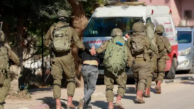 Des soldats israéliens arrêtent un Palestinien lors d'une opération militaire dans la ville de Qalqiya, en Cisjordanie occupée, le 4 décembre 2025.