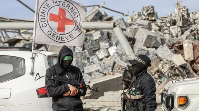 Des militants palestiniens du Hamas sécurisent la zone tandis que des travailleurs égyptiens accompagnés de membres du Comité international de la Croix-Rouge (CICR) recherchent les restes du dernier otage israélien dans le quartier de Zeitoun, à Gaza, le 8 décembre 2025.