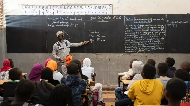 Un professeur d'anglais montre le tableau noir pendant un cours d'anglais à l'école primaire Alassane Ndiaye Allou à Dakar, le 30 janvier 2025.