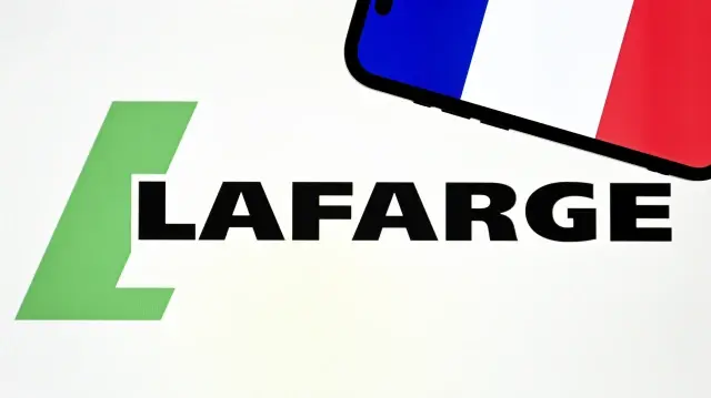 Le drapeau français apparaît sur l’écran d’un téléphone portable devant le logo de Lafarge, à Ankara, le 6 novembre 2025.