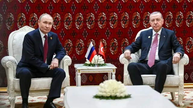 Sur cette photo collective diffusée par l'agence d'État russe Sputnik, le président russe Vladimir Poutine et le président turc Recep Tayyip Erdogan tiennent une réunion à Achgabat le 12 décembre 2025. 
