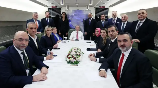 Le président turc Recep Tayyip Erdogan (au centre) s'adresse aux journalistes à bord de l'avion qui le ramène d'Achgabat, au Turkménistan, après sa participation au Forum international sur la paix et la sécurité, à Ankara, en Türkiye, le 12 décembre 2025. 