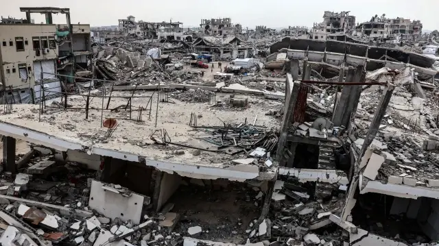 Des Palestiniens marchent parmi les décombres des bâtiments détruits dans la ville de Gaza, le 29 novembre 2025.