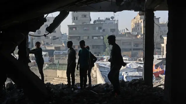 Des Palestiniens inspectent les décombres d'un bâtiment endommagé appartenant au ministère des Affaires religieuses, qui abritait des personnes déplacées dans le quartier de Zeitoun à Gaza, le 20 novembre 2025, au lendemain d'une attaque de l'armée israélienne.