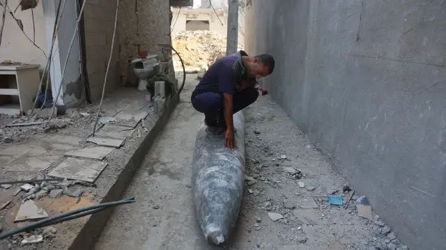 Un homme assis sur un missile non explosé dans le quartier d'Al-Tuffah à Gaza, le 12 novembre 2025.
