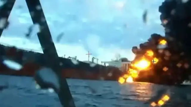 Cette capture d'écran tirée d'images diffusées par le Service de sécurité de l'Ukraine (SBU) le 29 novembre 2025 montre de la fumée s'élevant d'un cargo en feu dans la mer Noire, au large des côtes turques, dans le contexte du conflit russo-ukrainien.