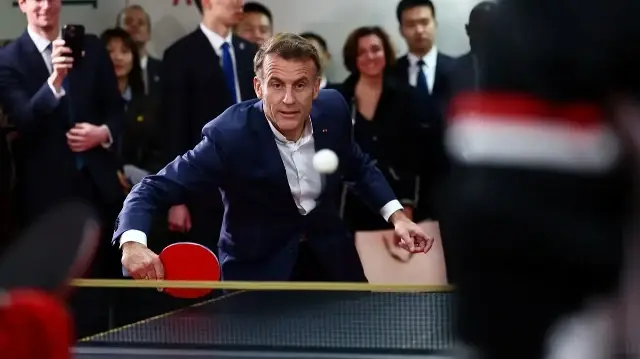 Le président français Emmanuel Macron joue au tennis de table lors d'une rencontre avec Alexis Lebrun et Félix Lebrun, ainsi que des joueurs de tennis de table chinois et français et des étudiants de l'université du Sichuan à Chengdu, dans la province du Sichuan, dans le sud-ouest de la Chine, le 5 décembre 2025. 