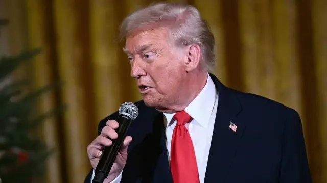 Le président américain Donald Trump s'entretient avec son épouse, la Première dame Melania Trump, alors qu'ils assistent à un concert d'Andrea Bocelli dans la salle Est de la Maison Blanche à Washington, DC, le 5 décembre 2025. 

