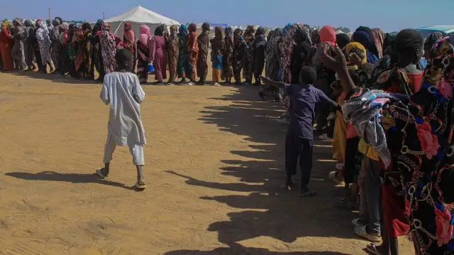 Des femmes soudanaises qui ont fui El-Fasher font la queue pour recevoir de l'aide humanitaire au camp de déplacés d'Al-Afad, dans la ville d'Al-Dabba, au nord du Soudan, le 25 novembre 2025. 
