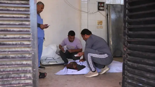 Des Palestiniens pleurent la mort d'Ashraf Khadora, 51 ans, tué lors d'une frappe israélienne à l'hôpital Al-Aqsa de Deir al-Balah, dans le centre de la bande de Gaza, le 26 novembre 2025.