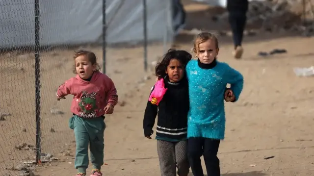 Des enfants palestiniens devant leurs tentes, au milieu des décombres des bâtiments détruits à Jabalia, dans le nord de la bande de Gaza, le 9 décembre 2025.