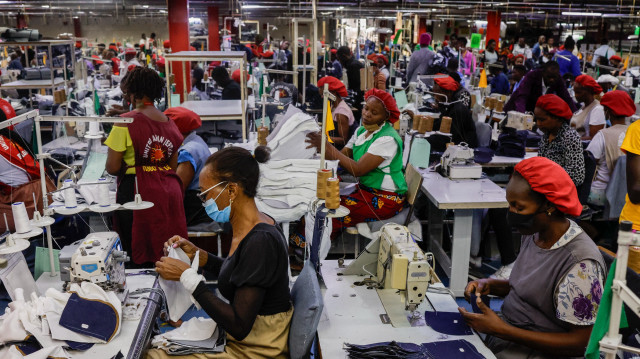 Des ouvriers utilisent des machines à coudre pour assembler des pièces de tissu afin de fabriquer des jeans dans l'usine textile United Aryan, située dans la zone franche d'exportation (EPZ) de Nairobi, le 4 février 2025.