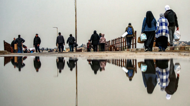 Des Palestiniens traversent le pont de Wadi Gaza, longeant la rue al-Rashid, pour regagner leur domicile entre Gaza et Nuseirat, dans le centre de la bande de Gaza, le 10 février 2025.

