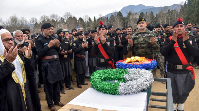 Le personnel de sécurité fait des prières pendant la cérémonie funéraire d'un officier de police tué pendant qu'il escortait une équipe de vaccination contre le poliovirus dans le district de Bajaur, dans la province de Khyber Pakhtunkhwa, au nord-ouest du pays, le 19 février 2025.