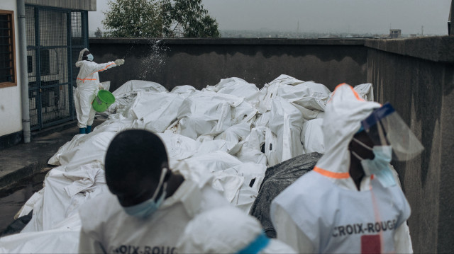 Des membres de la Croix-Rouge congolaise désinfectent des sacs mortuaires à la morgue de l'hôpital général de Goma, le 1er février 2025. Le groupe M23, soutenu par le Rwanda, progresse vers le sud dans l'est de la République démocratique du Congo, riche en minerais, alors que les Nations unies annoncent que l'escalade du conflit a fait au moins 700 morts en moins d'une semaine. Le M23 s'est emparé de Goma, centre commercial vital de l'est, après d'intenses combats cette semaine, et a promis de marcher jusqu'à la capitale de la République démocratique du Congo.