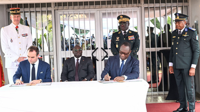 Le ministre ivoirien de la Défense, Tene Birahima Ouattara (2e à droite), et le ministre français des Forces armées, Sébastien Lecornu (2e à gauche), signent un document au camp militaire général Ouattara Thomas d'Aquin, ancienne base française du 43e bataillon d'infanterie de marine, à Port-Bouet, à Abidjan, le 20 février 2025.