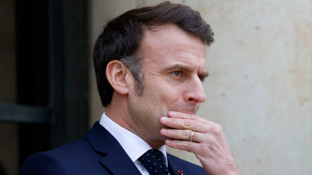 Le président français Emmanuel Macron fait un geste alors qu'il attend le président par intérim de la Roumanie pour des entretiens au palais présidentiel de l'Élysée à Paris, le 19 février 2025, au lendemain d'une réunion avec sept pays européens, axée sur l'Ukraine, dans la conviction que "la Russie est une menace existentielle" pour le continent.