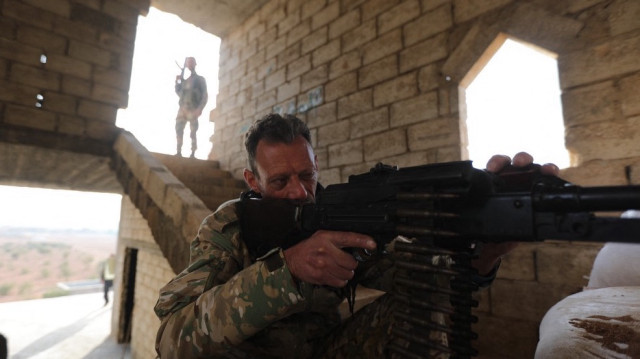 Un combattant syrien soutenu par la Turquie est assis derrière une mitrailleuse dans une position fortifiée à Jarablus, près de la frontière avec la Turquie, dans le nord de la province syrienne d'Alep tenu par les rebelles, le 21 novembre 2022.