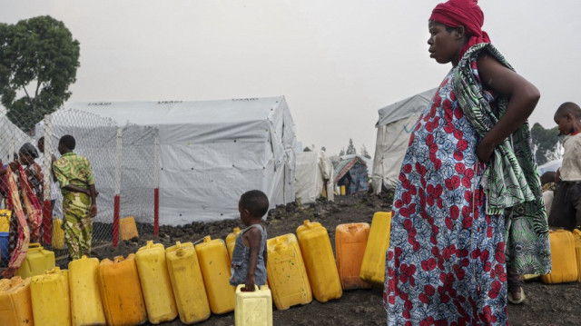 Des enfants se joignent à une file de jerrycans à un point d'eau au camp de Lushagala pour les personnes déplacées dans la ville de Goma, la capitale et la plus grande ville de la province du Nord-Kivu dans la région orientale de la République démocratique du Congo, le 3 février 2025.