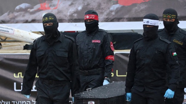 Des militants palestiniens portent l'un des cercueils alors qu'ils remettent les corps de quatre otages israéliens à la Croix-Rouge à Khan Yunis, dans le sud de la bande de Gaza, le 20 février 2025.