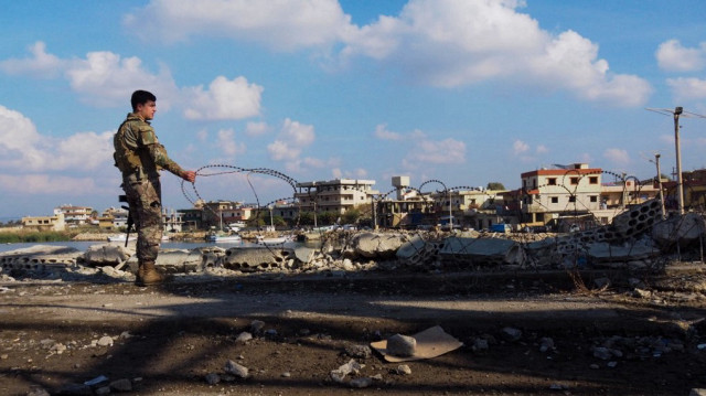 Un soldat libanais installe des barbelés à la frontière libano-syrienne à Al-Arida, le 9 décembre 2024.