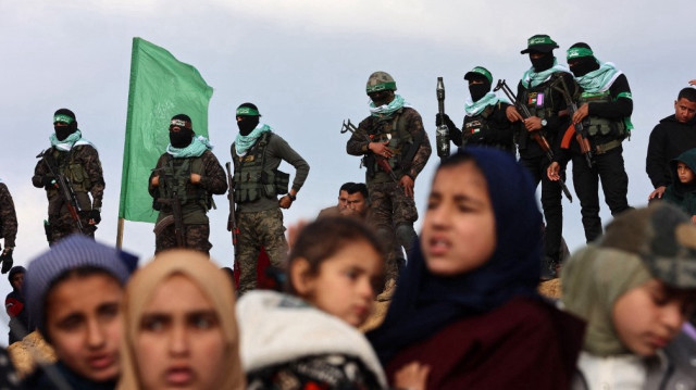 Des militants du Hamas palestinien et des personnes se rassemblent sur le site de la remise des corps de quatre otages israéliens à Khan Yunis, dans le sud de la bande de Gaza, le 20 février 2025.
