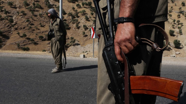 Un membre du Parti des travailleurs du Kurdistan (PKK) porte un fusil automatique sur une route dans les montagnes de Qandil, le quartier général du PKK dans le nord de l'Irak, le 22 juin 2018.