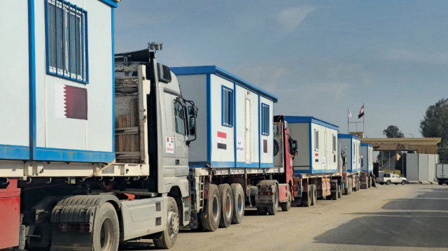 Des camions transportant des maisons mobiles sont alignés du côté égyptien du poste frontière de Rafah avec la bande de Gaza, le 20 février 2025.